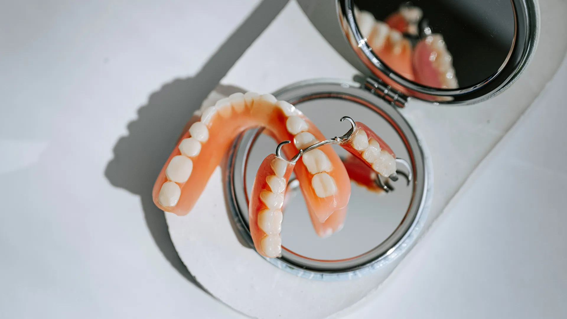 Set of dentures placed on mirror.