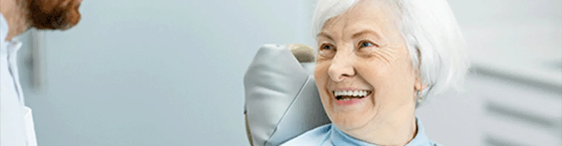 An older woman smiling at the dentist.