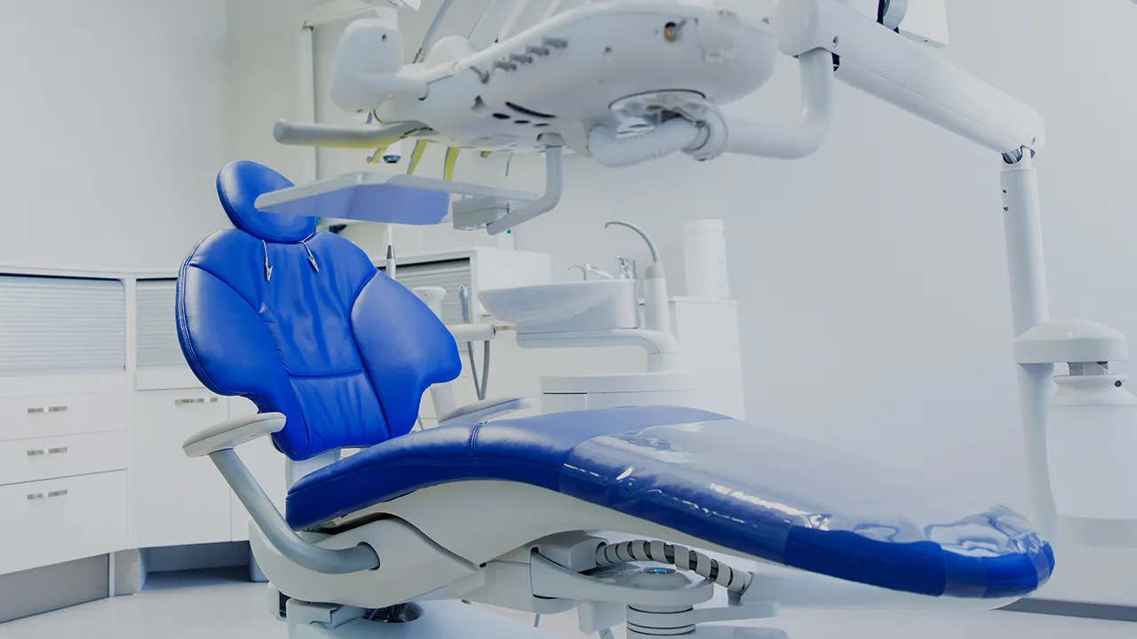 Modern dental chair with blue upholstery in a clean, bright dental office.