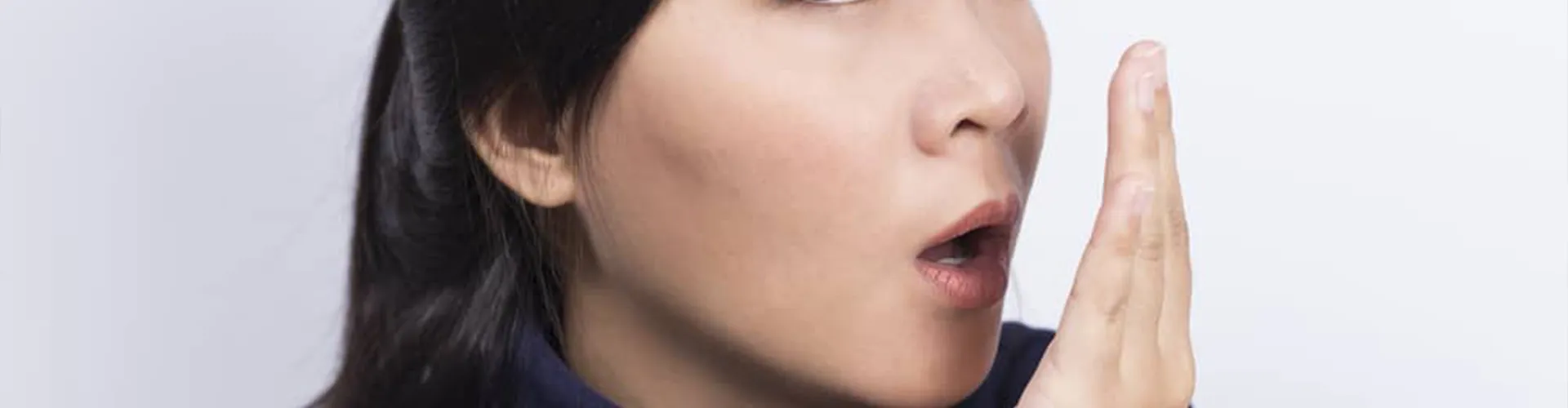 Woman smelling her breath.