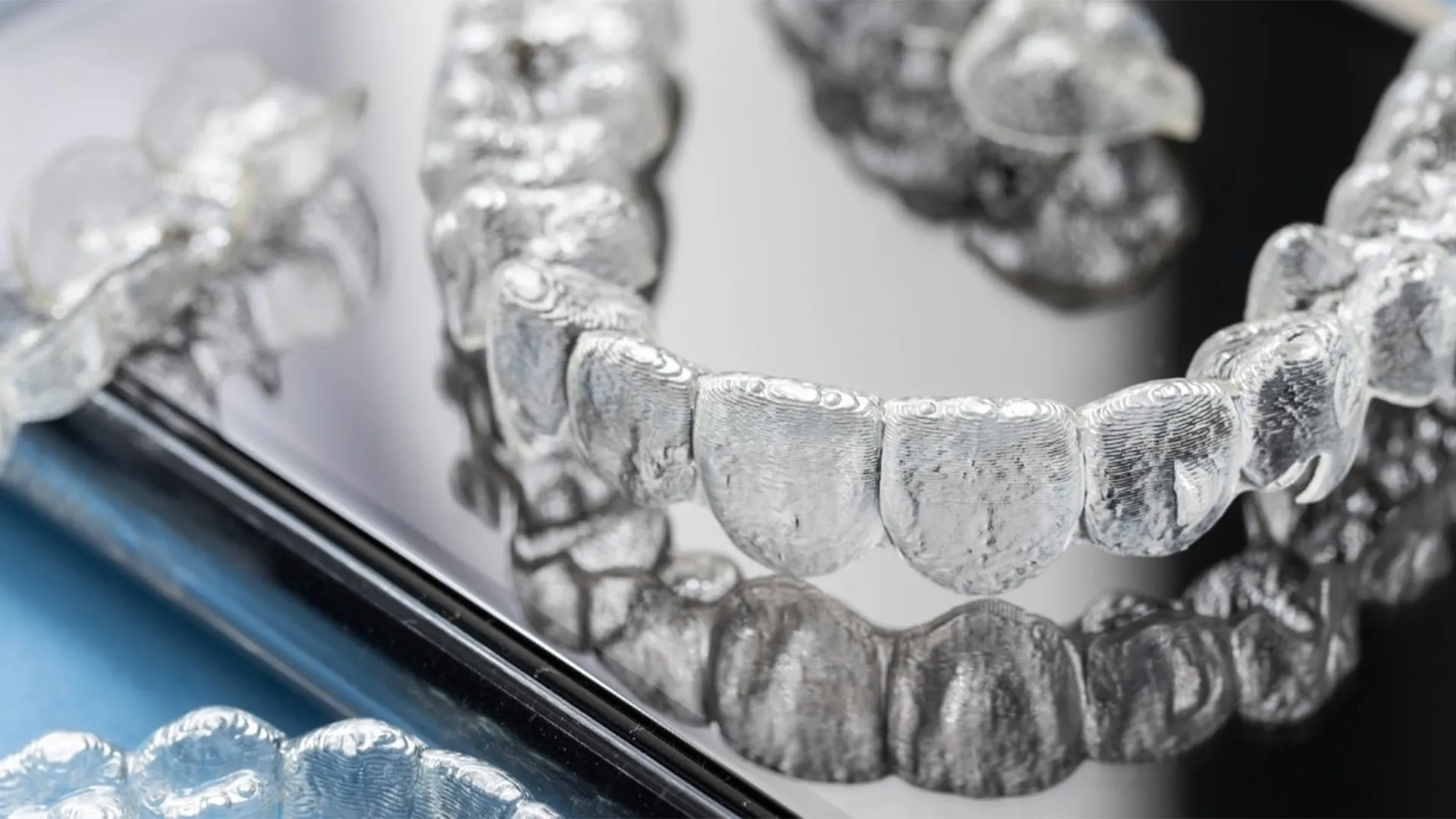 Clear dental aligners placed on reflective surface