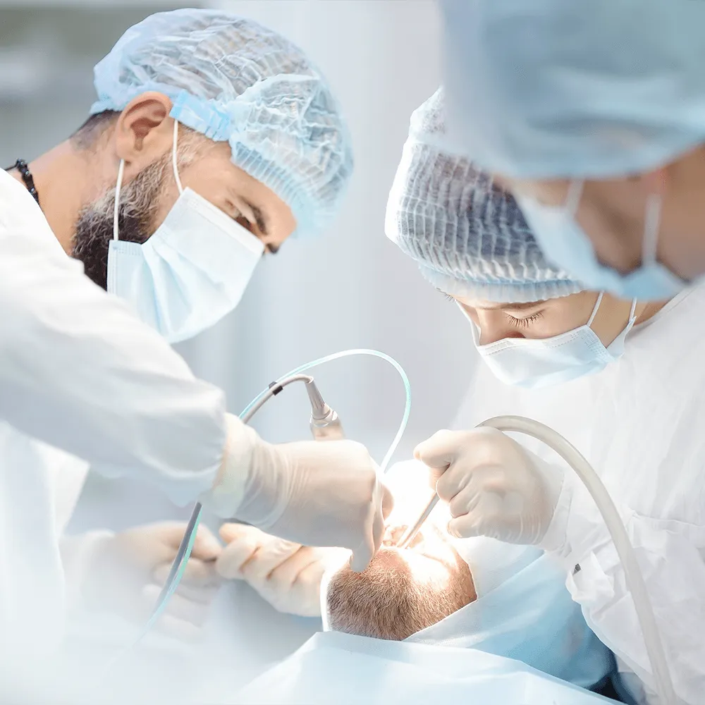 Dental surgeons performing oral surgery on a patient.