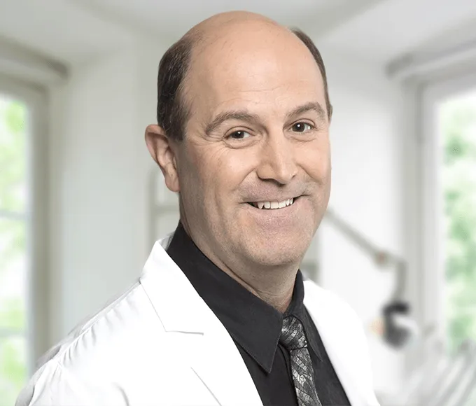 Dr. Fernandez, dentist, smiling in his office
