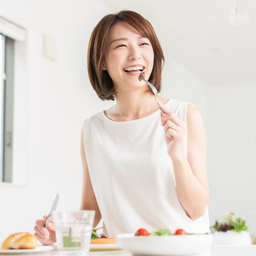 Happy woman enjoying a healthy meal of steak and salad.