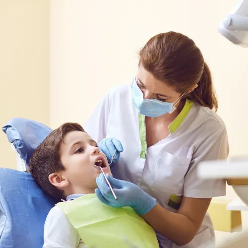 dentist using dental tools in child's mouth