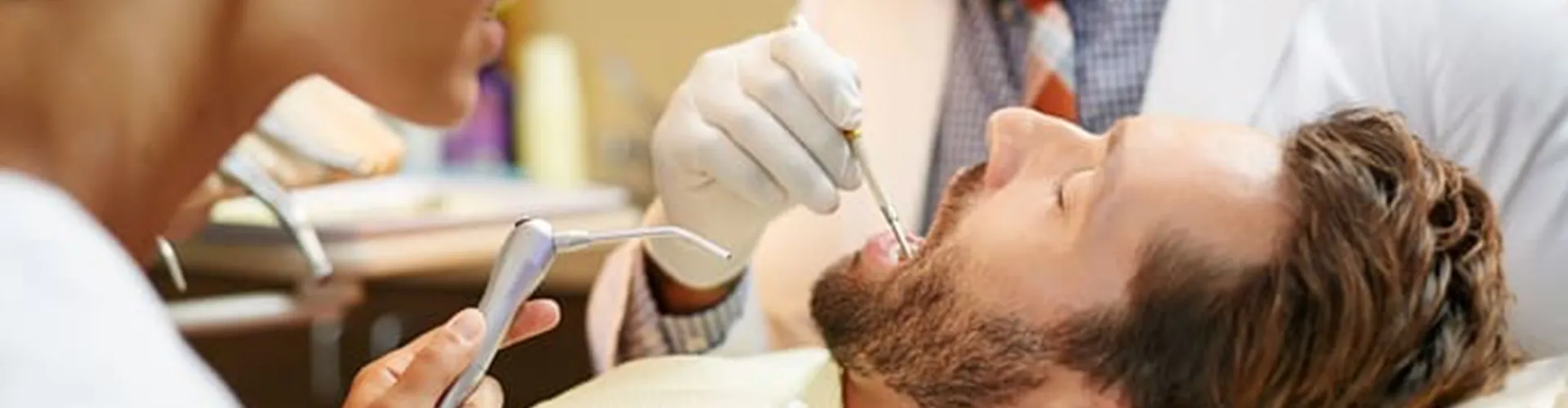Dentist examinating a man.
