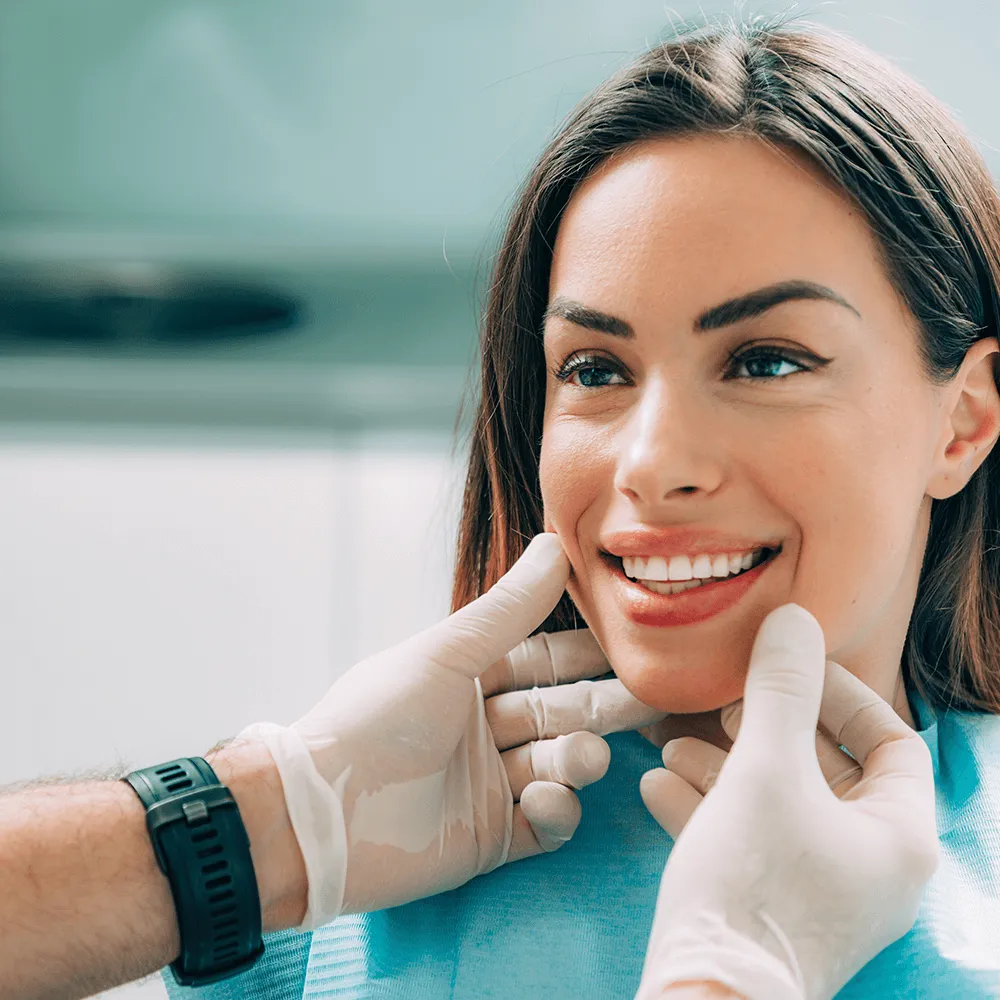 Dentist examining patient's smile and jawline.