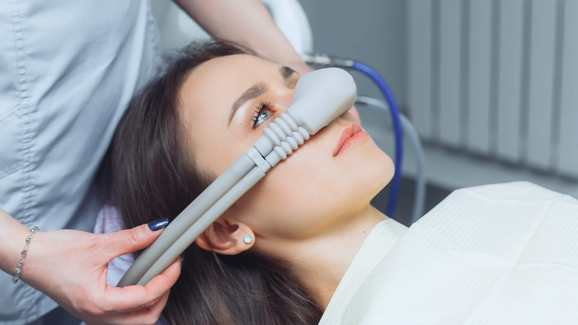 Patient receiving dental sedation with mask.
