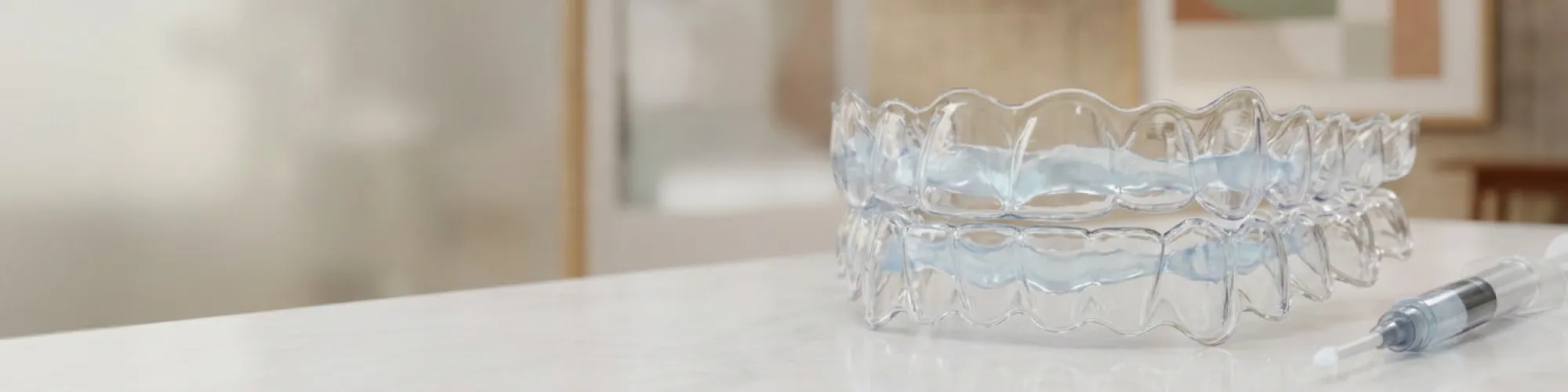 Clear aligners with whitening gel on surface.