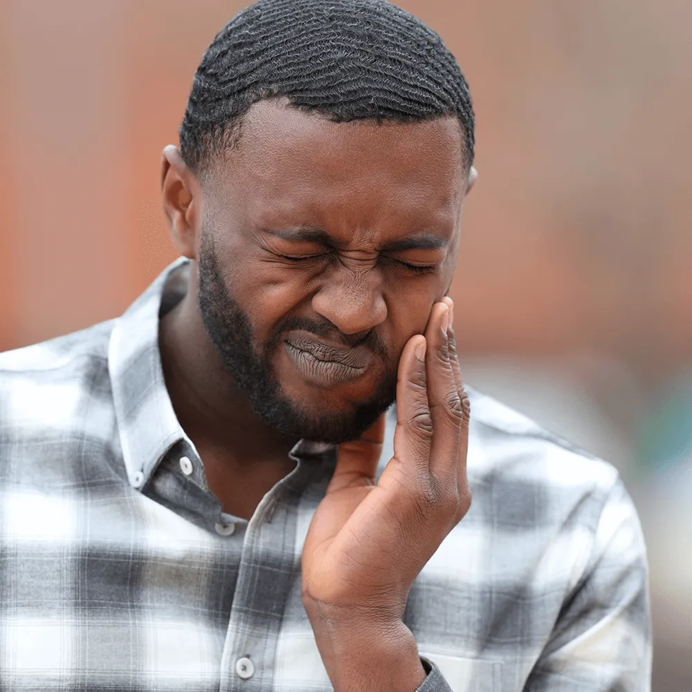 Man holding his jaw, experiencing tooth pain.