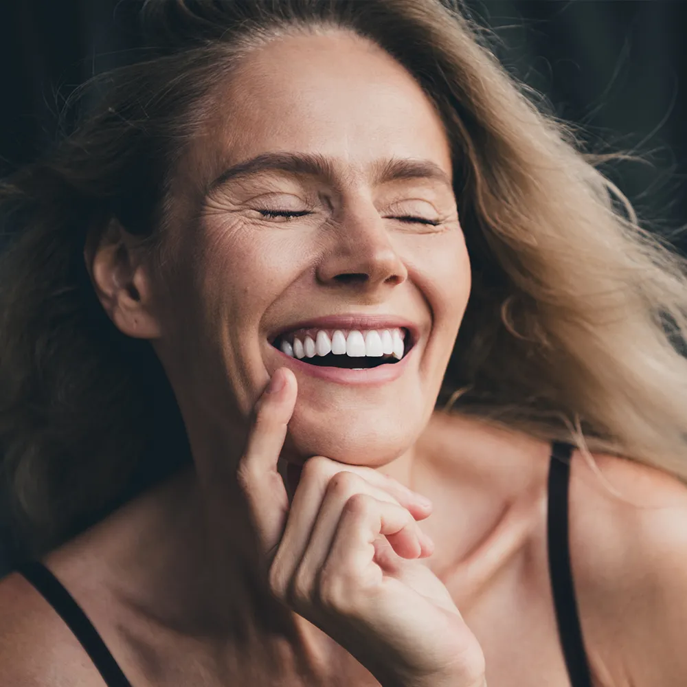 Happy woman with bright, healthy smile and glowing skin.