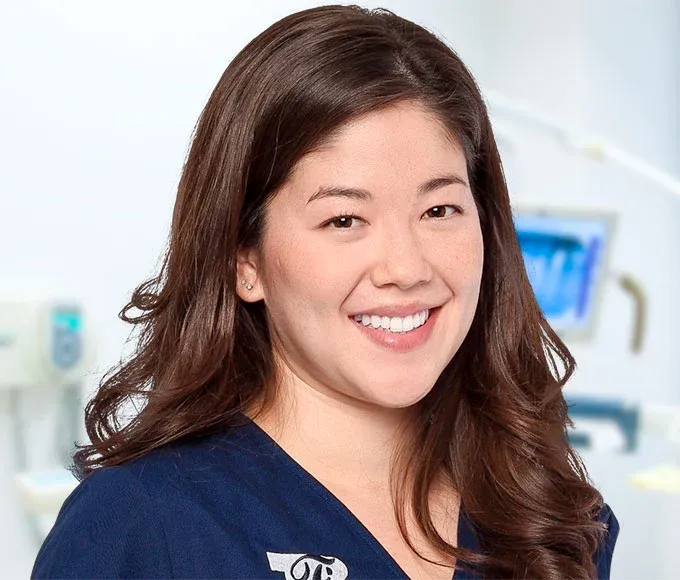 Smiling female dentist in scrubs