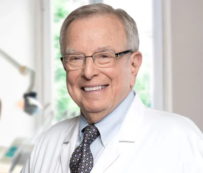 Dr. Torgan, experienced dentist, smiling in his office.