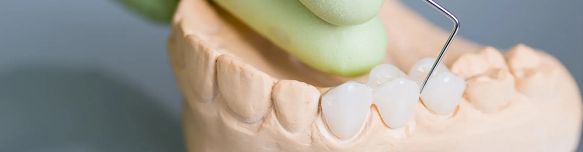 Dental tool being used on a denture model.