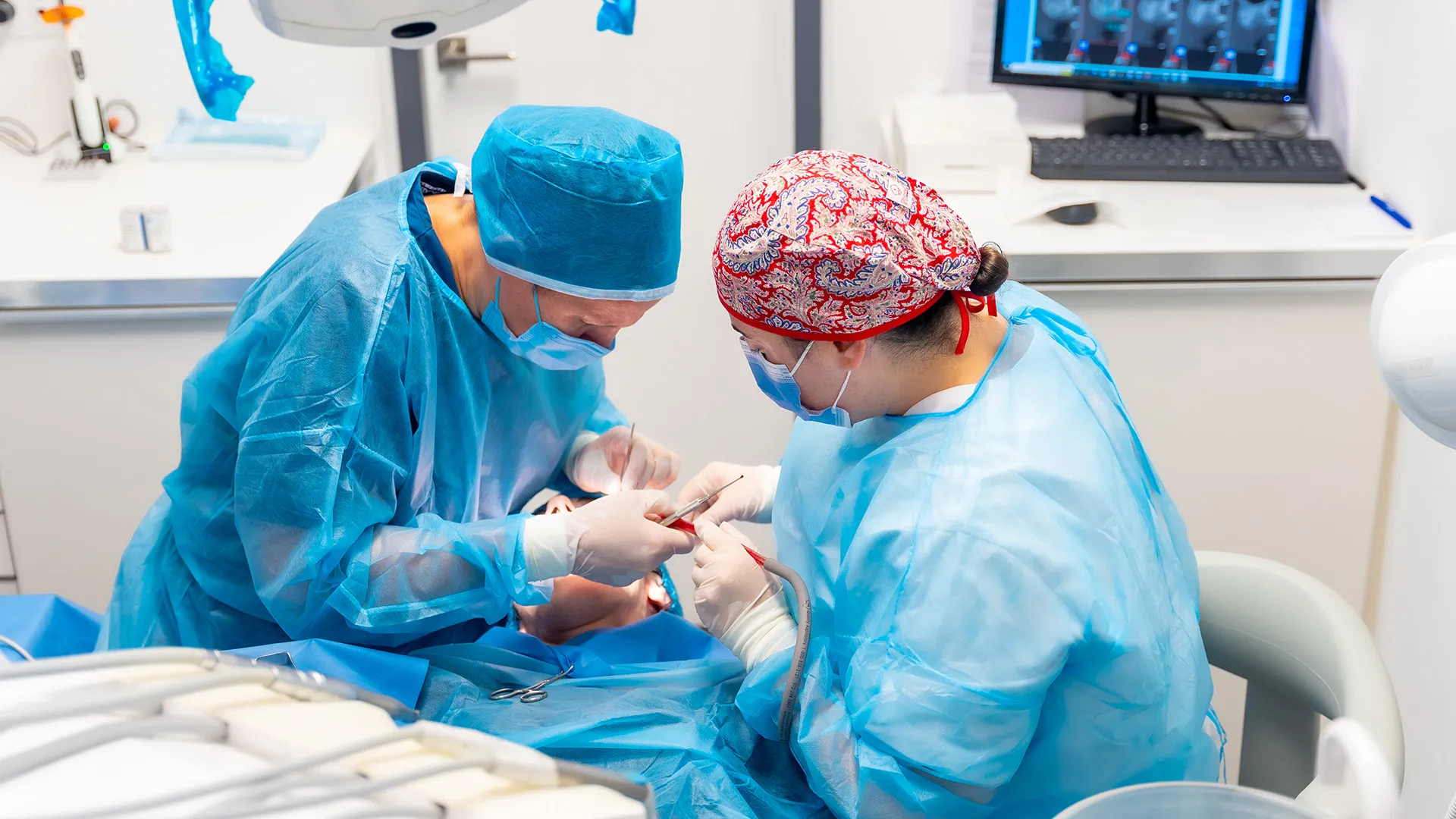 Dentists performing oral surgery in clinic