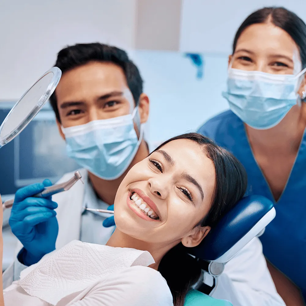 Happy patient with dentist and dental hygienist