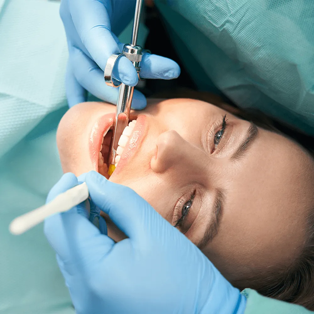 Close-up of dentist administering local anesthesia during dental procedure.