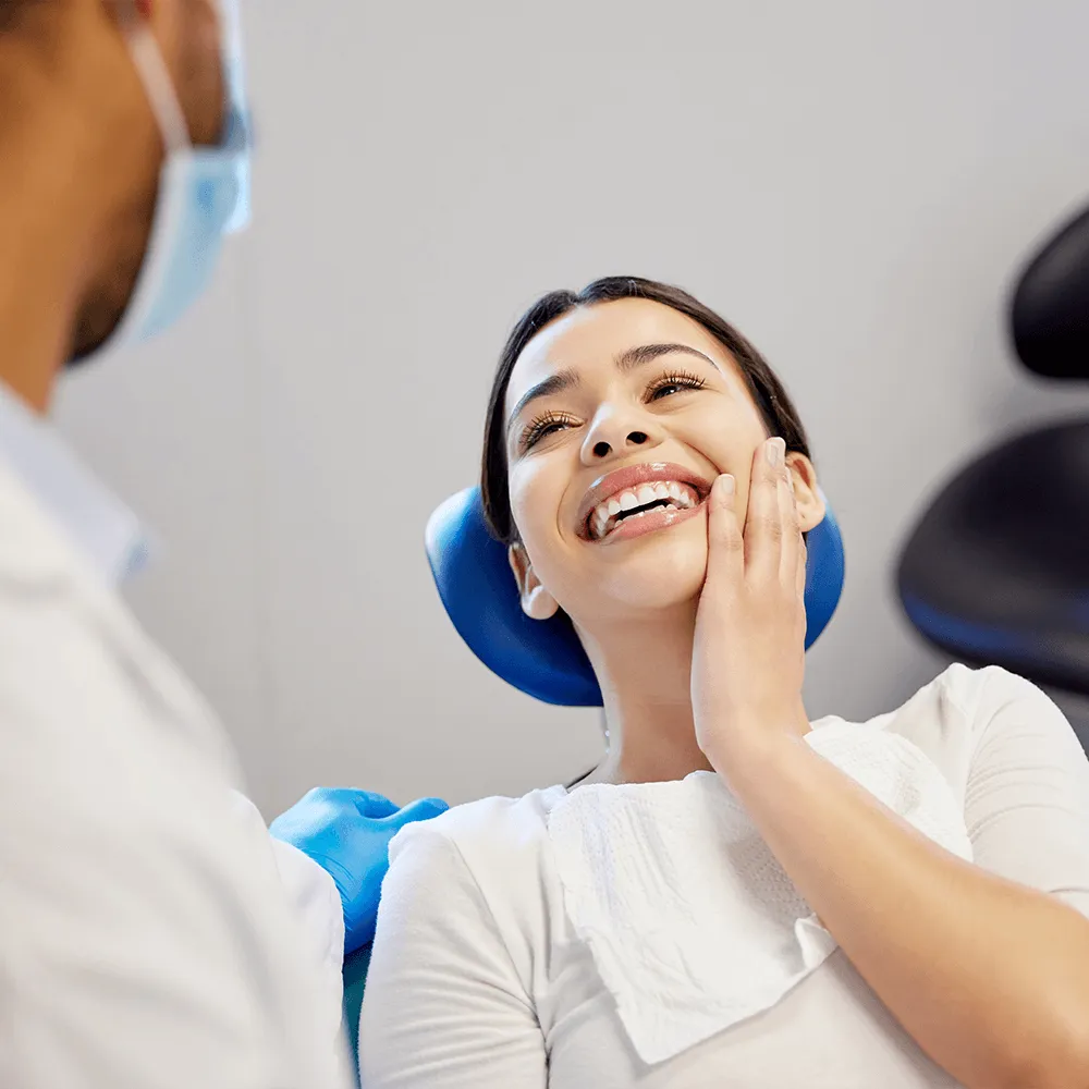 Happy female patient smiling at her dentist during a dental checkup.
