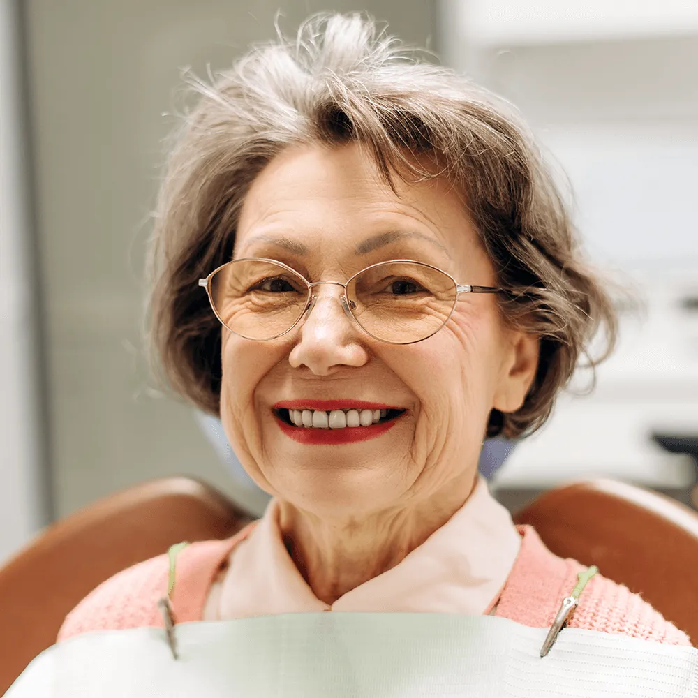 Happy senior woman with healthy smile after dental treatment.