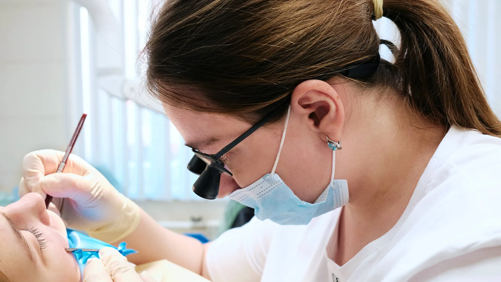 Dentist performing tooth extraction procedure.