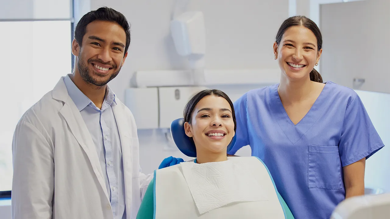 Happy dental patient with dentist and dental hygienist
