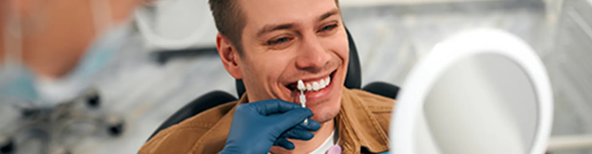 Man smiling with veneers displayed in front of his teeth.