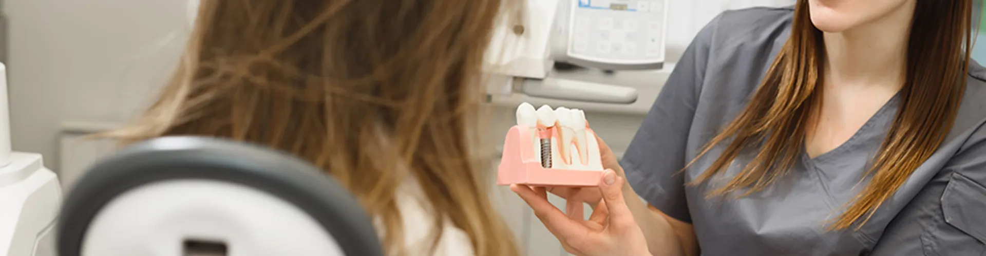 A dentist showing implants to a patient.