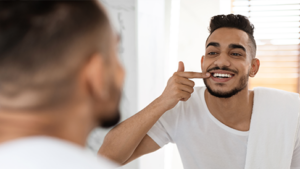 man smiling into mirror