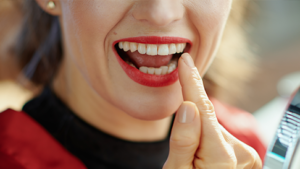 smiling woman pointing at teeth
